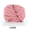 A ball of pink chunky chenille yarn is shown on a white surface.