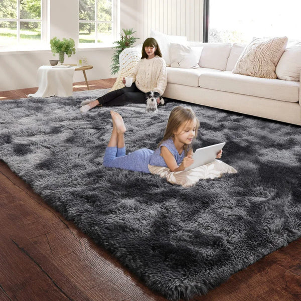 A young girl lies on a dark gray luxury velvet anti-slip floor mat indoors near a window.