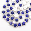 A close-up of silver and blue crystal rhinestone sew-on buttons arranged in a sunflower pattern.