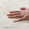 A hand rests on a thick suede non-slip mat, showing the soft texture and skin-friendly material.