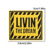 Yellow and black striped iron-on embroidery patch with the text LIVIN THE DREAM