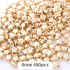 A pile of gold star-shaped acrylic beads for jewelry making, 6mm size, with 100 pieces.