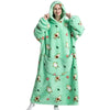 A woman wearing a light green sherpa fleece oversized blanket hoodie with a floral pattern.