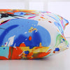 A close-up of a Mulberry Silk Zipper Pillowcase with a vibrant floral print featuring blue, orange, and white colors.