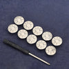 A silver metal tool with a handle is shown alongside several round metal snap buttons on a dark blue fabric.