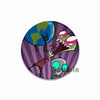 An enamel pin featuring a stylized alien character with green skin and large eyes against a purple background.