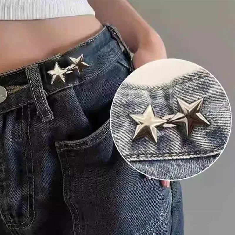 Close-up of adjustable metal star brooch pins attached to dark denim jeans.