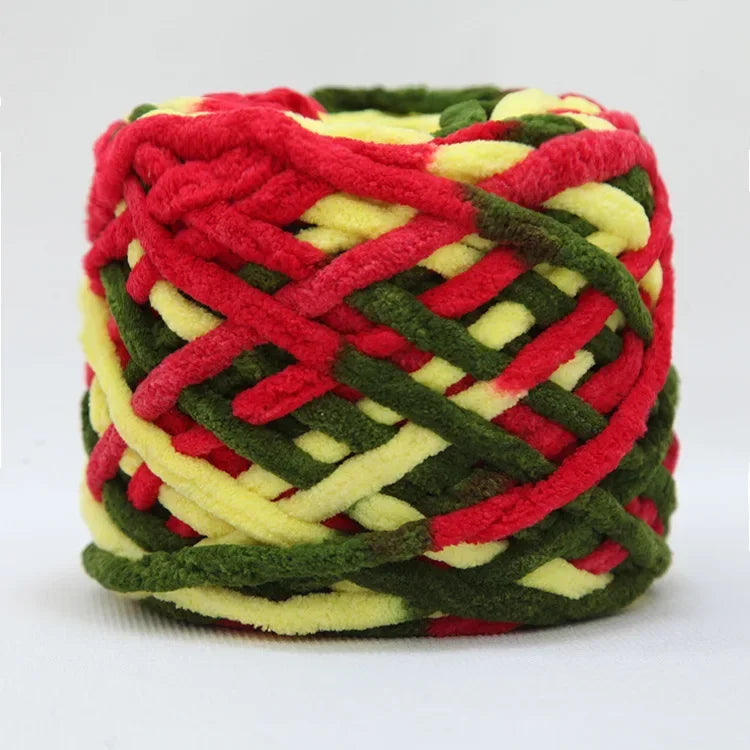 A ball of red, green, and yellow chenille knitting yarn with a woven texture.