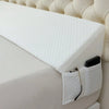 A white adjustable bed wedge pillow with a quilted cover is shown resting on a white bed surface.