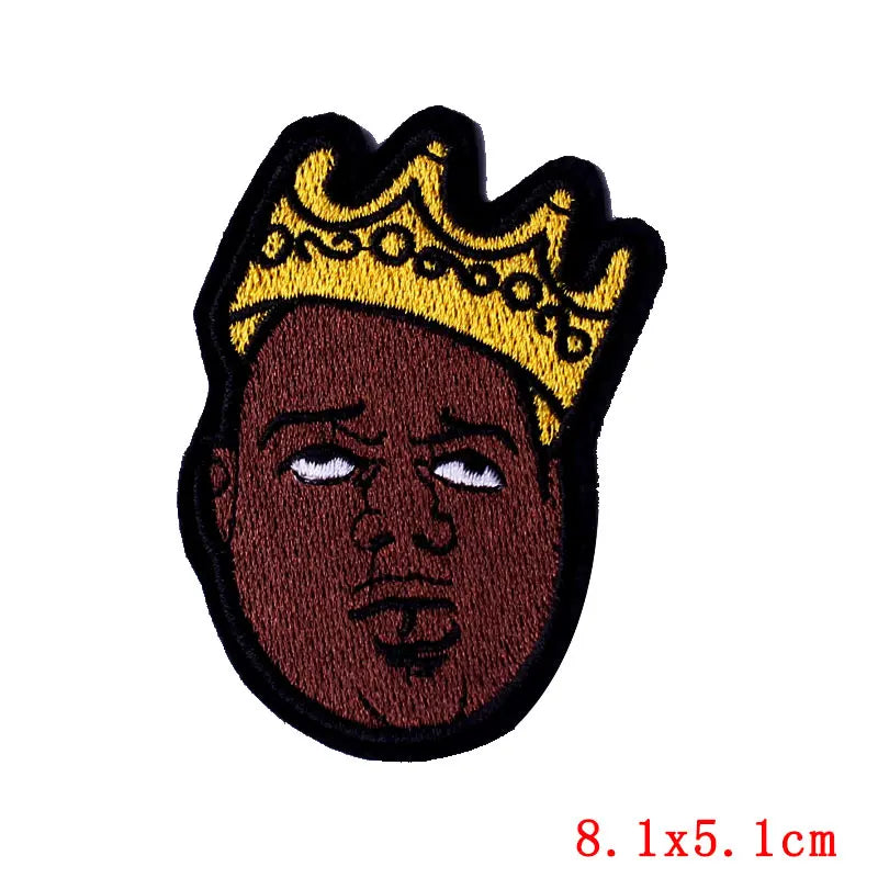 Embroidered skull iron-on patch featuring a crown above a dark skin tone face.