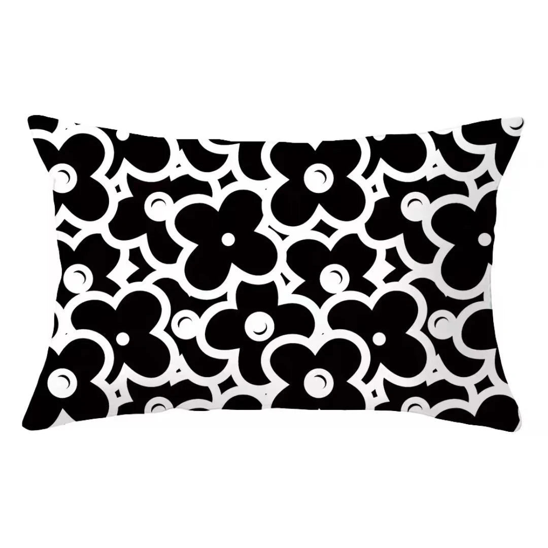 A decorative pillow cover featuring a black and white floral geometric pattern.
