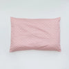 A square pink baby pillow cover with a repeating diamond pattern.