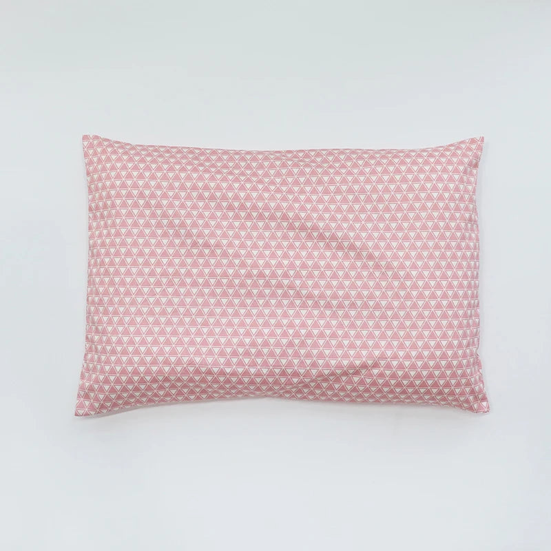 A square pink baby pillow cover with a repeating diamond pattern.