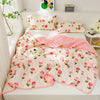 A pink and white quilted summer quilt set with floral patterns displayed on a bed.