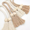 A collection of hand-woven wooden curtain tiebacks in various natural beige and cream tones.