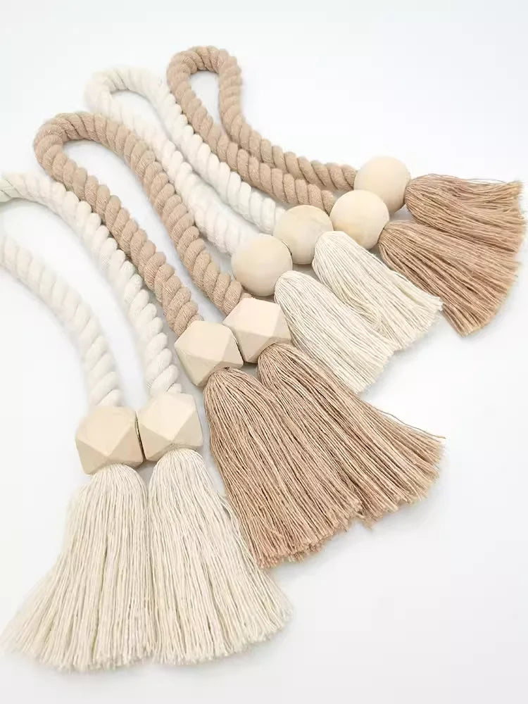 A collection of hand-woven wooden curtain tiebacks in various natural beige and cream tones.