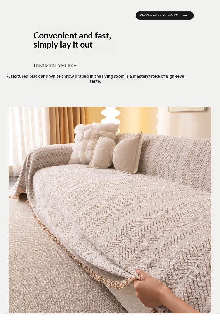 A beige chenille sofa protector draped over a light-colored sofa with a textured pattern.