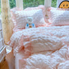 A pink lace seersucker duvet cover set with ruffled fabric and a white teddy bear on a bed.