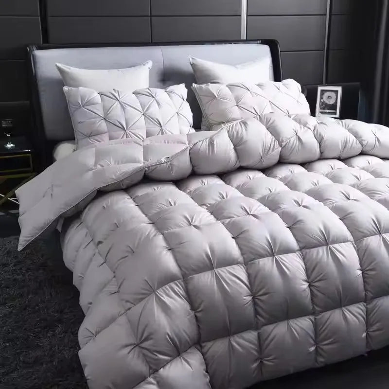 A white quilted duvet with a diamond pattern is displayed on a bed, suggesting winter warmth.