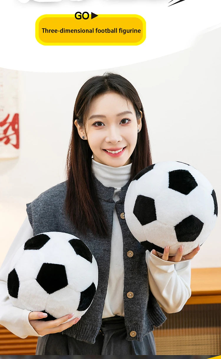 A woman holds a black and white three-dimensional football figurine plush toy.