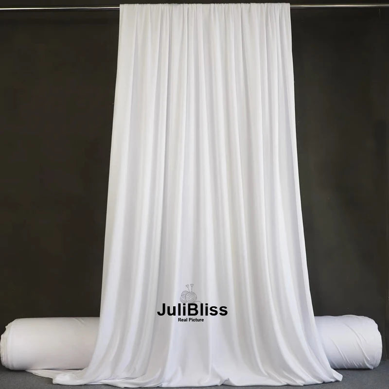 White draping stretch fabric hanging vertically against a dark background.
