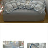 A light blue and gray floral bedding set featuring a duvet cover, pillows, and decorative accents.