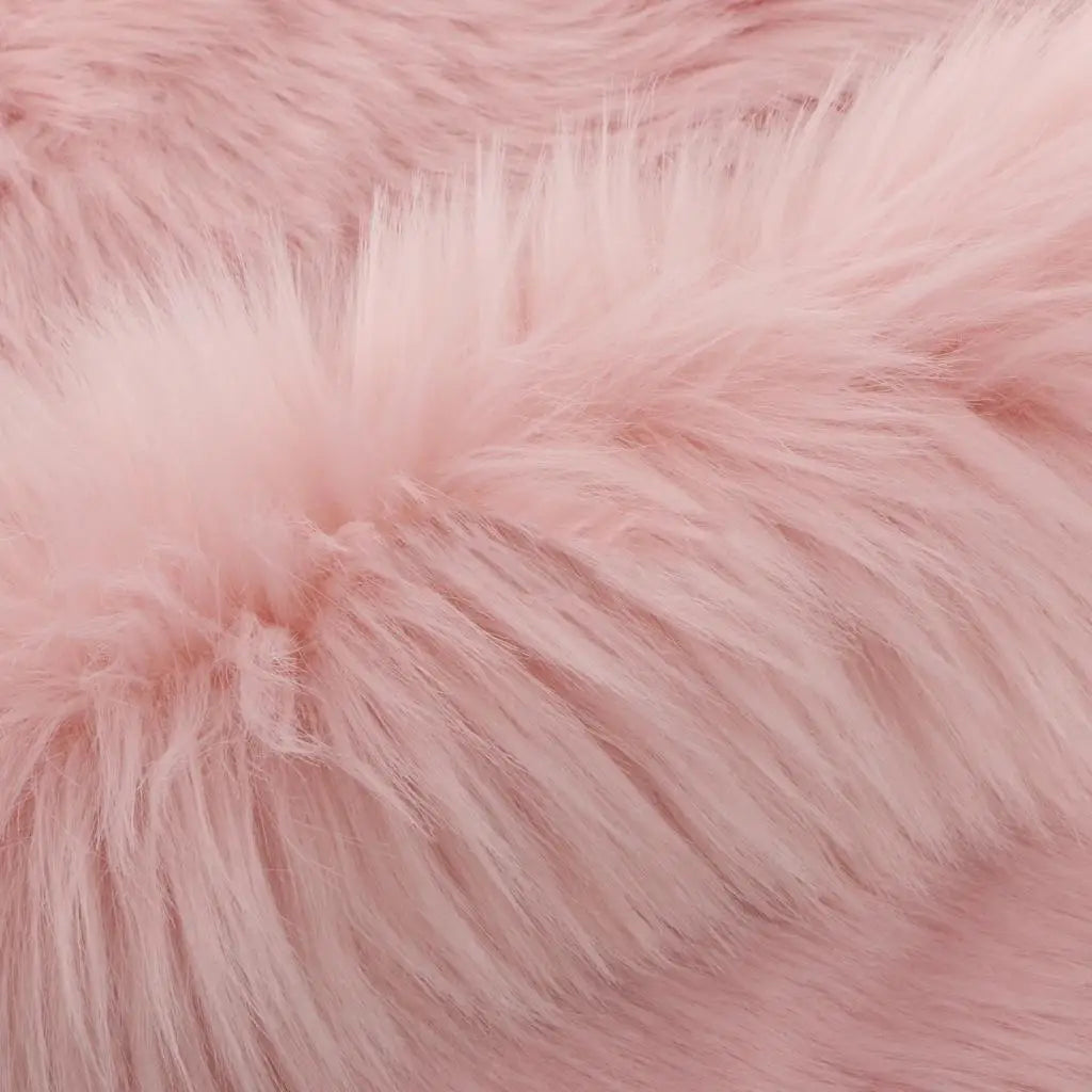 Close-up of a soft pink faux fur area rug showing its plush texture and fluffy fibers.