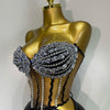A gold mannequin displays a sparkly diamond two-piece performance set featuring black mesh and rhinestones.