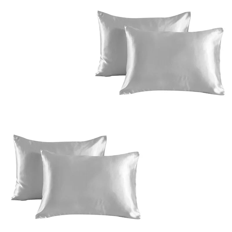 A set of two smooth, light gray satin silk pillowcases.