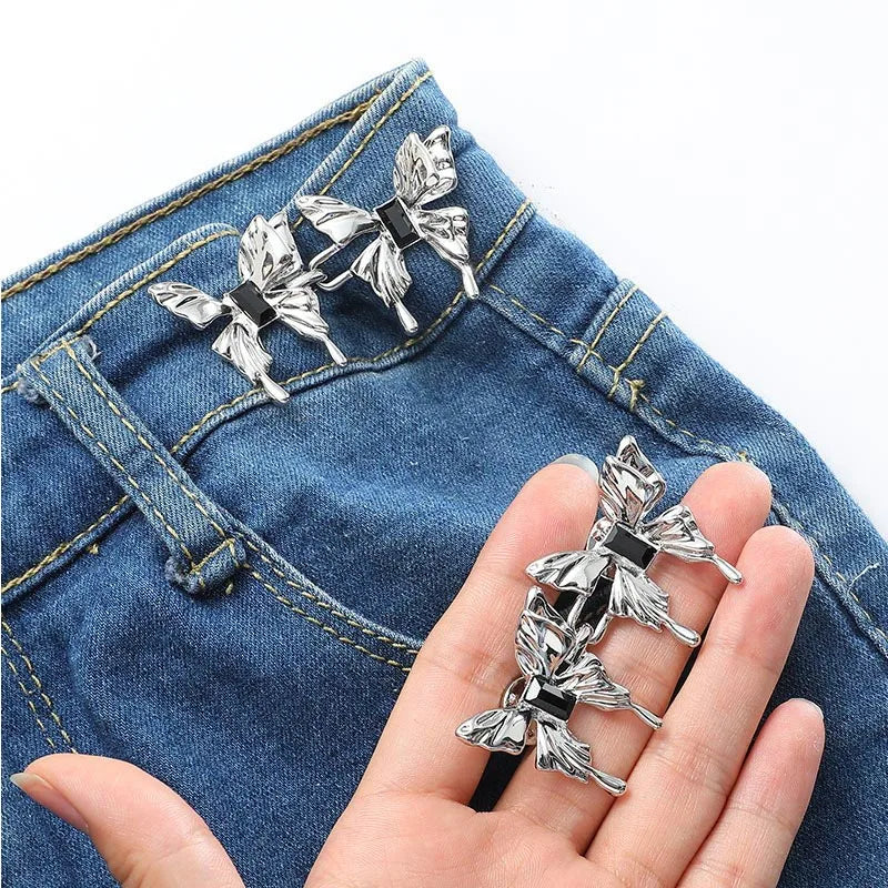 Silver adjustable waist clip brooches pinned onto blue denim fabric