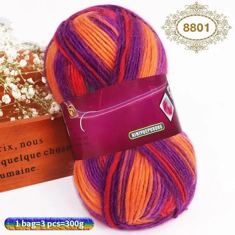 A ball of gradient dyed wool yarn featuring vibrant shades of purple, orange, and pink.