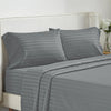 A set of gray striped bedding, including pillows and a fitted sheet, displayed on a bed.