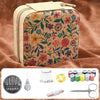 A rectangular fabric storage box with a floral pattern, next to various sewing tools including needles, a comb, and scissors.