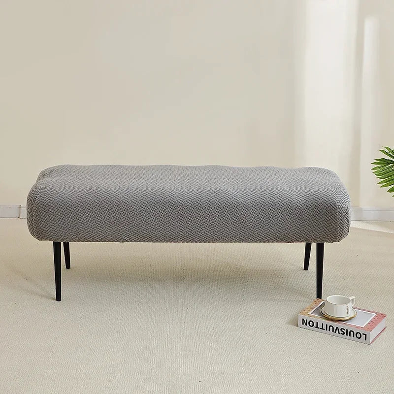 A gray elastic jacquard bench cover used as protection for a piano, dining, or entryway seat.