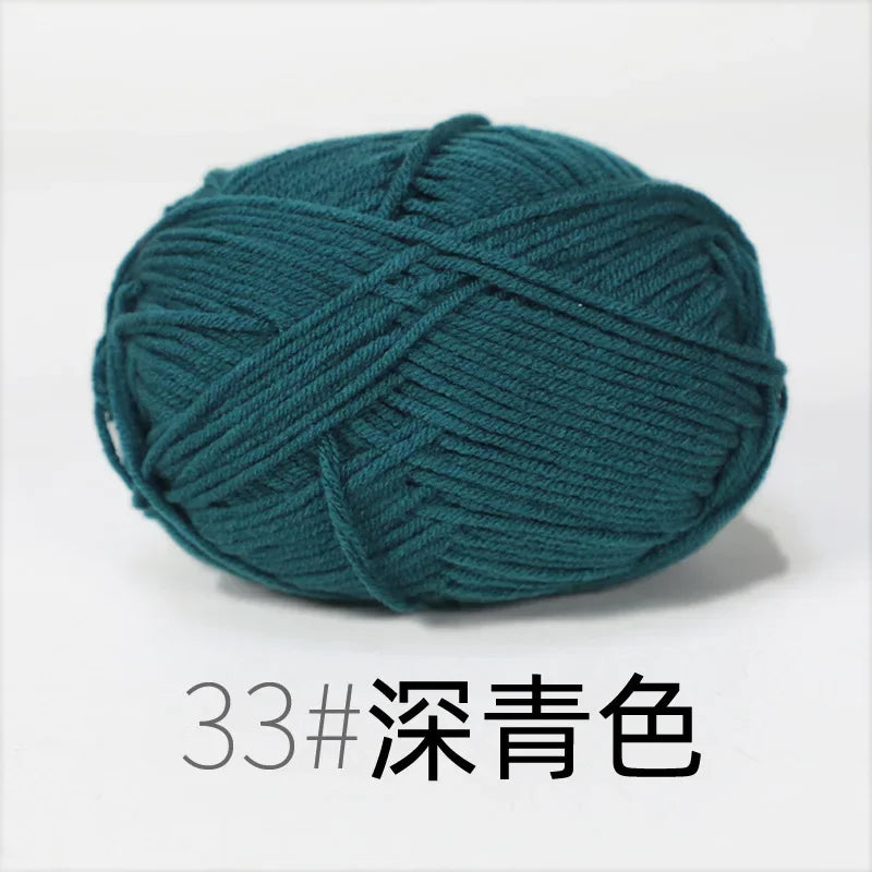 A ball of dark teal organic cotton 4ply knitting yarn.