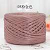 A spool of metallic pink cake yarn coiled into a round shape for crafting