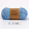 A skein of light blue hand-dyed yarn labeled Sweet Candy Yarns for crochet and knitting.