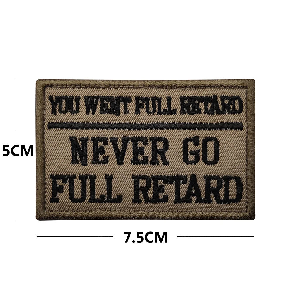 A dark brown embroidered patch with black text that reads YOU WENT FULL RETARD NEVER GO FULL RETARD