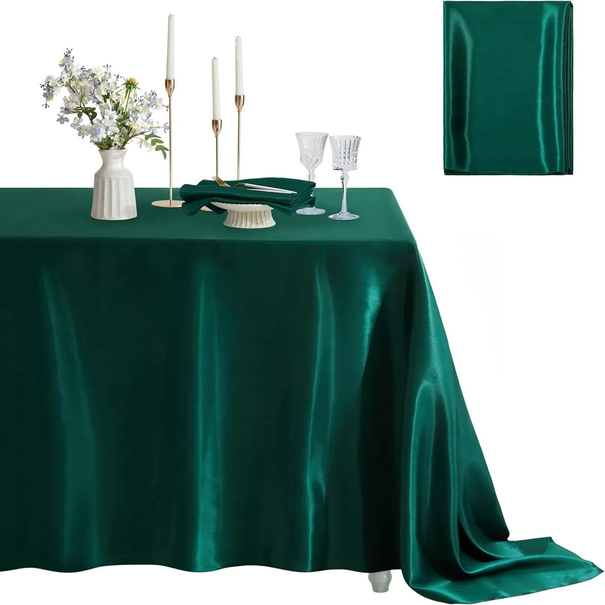 Emerald green satin tablecloth set with white floral centerpiece and candles