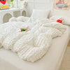 A white seersucker duvet cover and pillow set displayed on a white bed with decorative pillows.