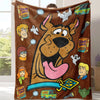 A brown flannel throw blanket featuring a large cartoon dog illustration and various Scooby Snacks related items.