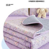 Purple floral quilted bedspreads stacked neatly on a bed, showcasing soft textures and delicate embroidery.