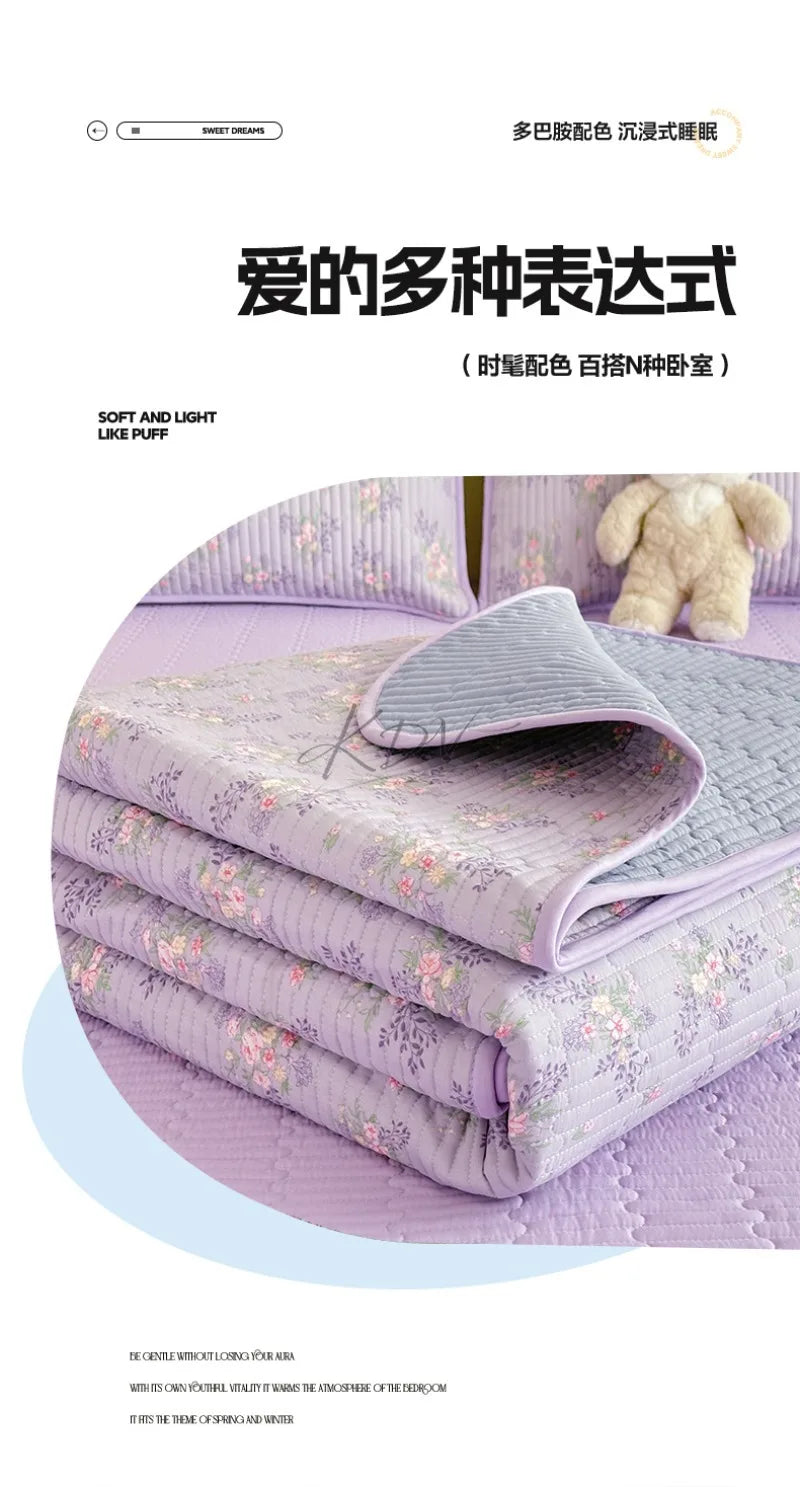 Purple floral quilted bedspreads stacked neatly on a bed, showcasing soft textures and delicate embroidery.