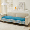 A beige sofa with a blue quilted cover featuring a white lace trim and displayed decor.