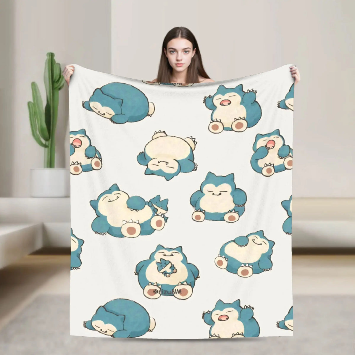 A woman holds up a white plush decorative throw blanket featuring cute blue and yellow animal characters.