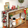 A linen table runner featuring Christmas pine cones and red berries on a wooden table.