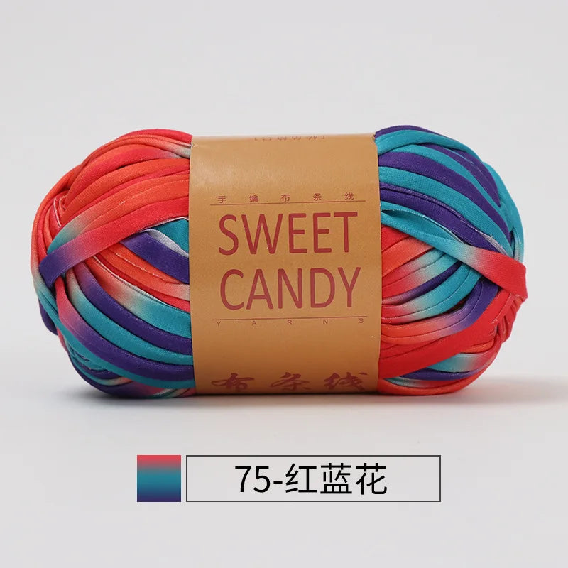 A ball of hand-dyed yarn featuring stripes of orange, pink, purple, and teal colors, labeled Sweet Candy.