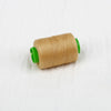 A spool of beige sewing thread with green tips is shown on a white background.