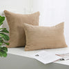 Two beige corduroy striped throw pillows resting on a white surface.