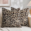 Three leopard print velvet pillow covers resting on a light-colored sofa.